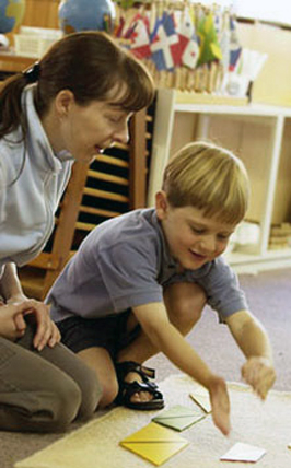 Montessori Lehrkraft, die ein Kind beobachtet